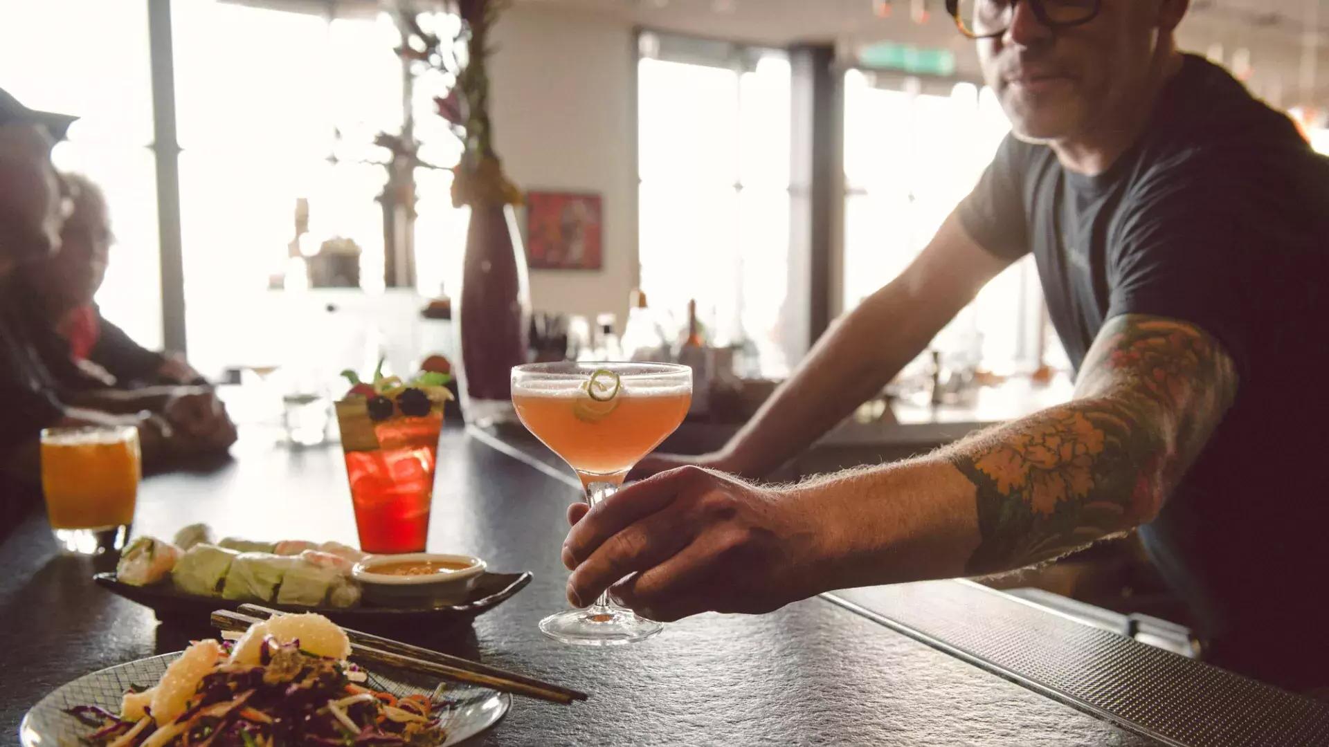 一位酒保在贝博体彩app一家酒吧为顾客提供鸡尾酒.